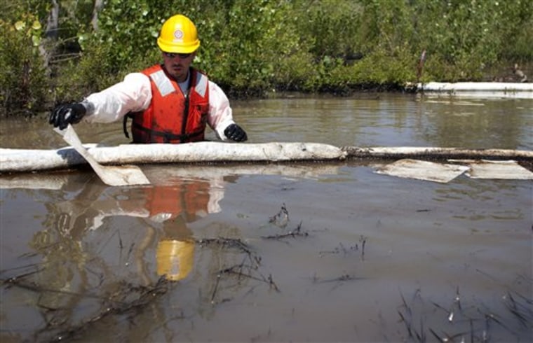 A cleanup worker uses oil absorbent materials on the Yellowstone River in Laurel, Mont., on Wednesday.